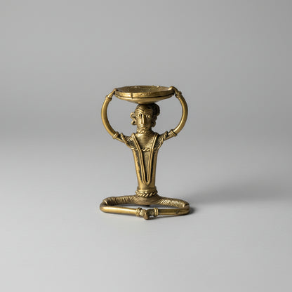 A handmade dhokra craft handmade brass diya holder having a tribal figurine