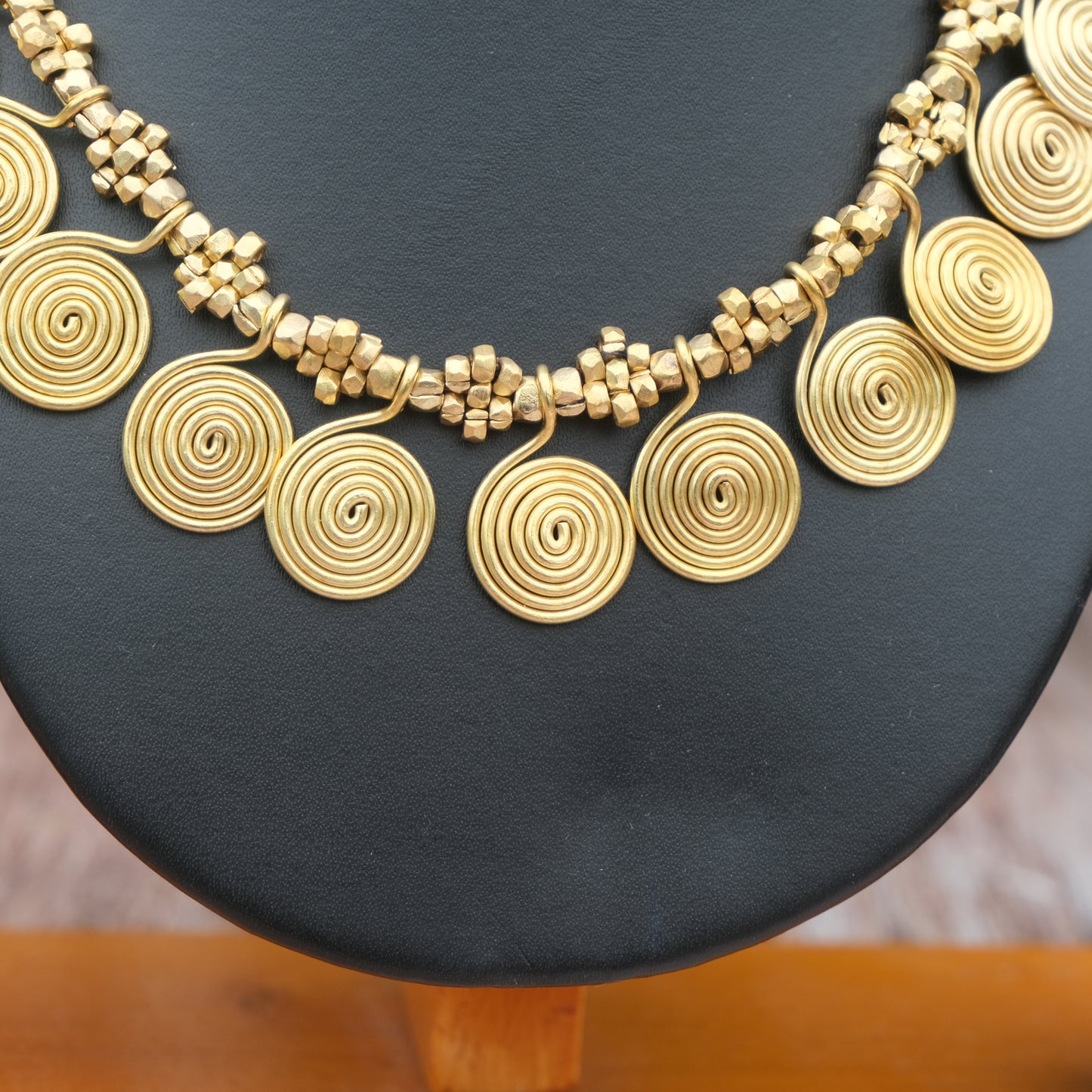 Handcrafted Dhokra golden beaded necklace featuring a circular design; ethically made by Odisha artisans using ancient lost-wax casting. A sustainable everyday statement piece for white linen shirts or tunics by KalaKart