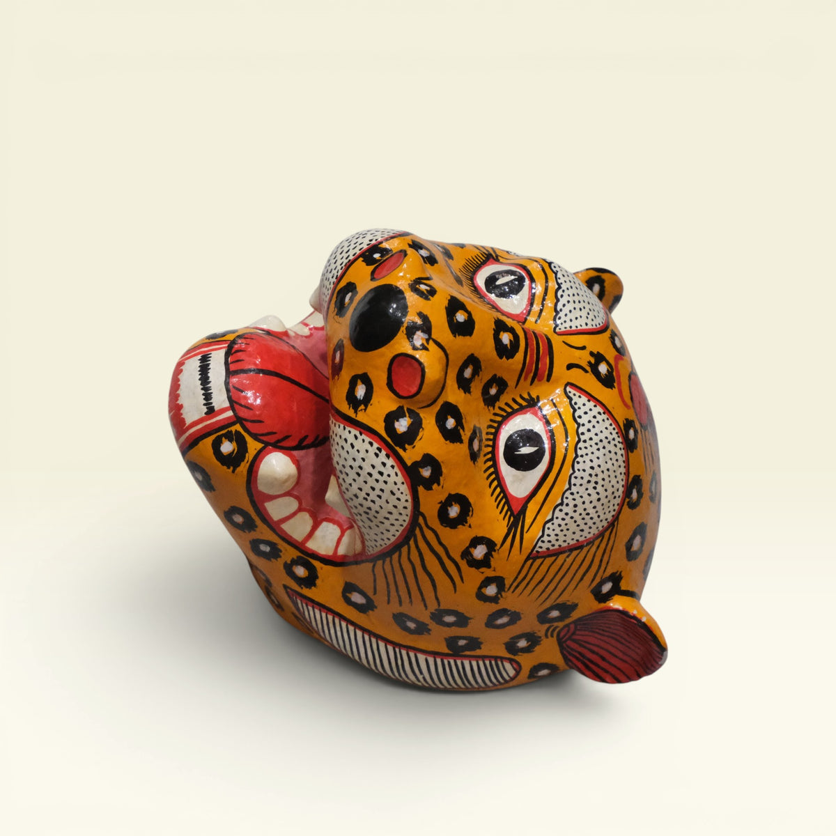 Handcrafted yellow and black hand-painted Pattachitra papier-mache tiger mask from Odisha featuring open jaws and intricate motif details.